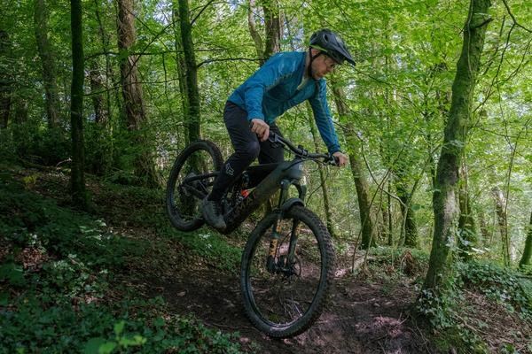 A mountain biker wearing a loose-fitting long sleeve jersey